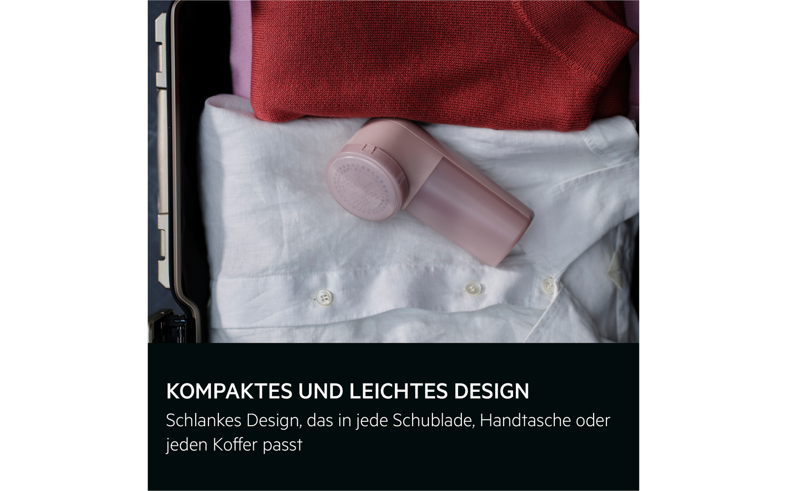 Geöffneter Koffer mit rotem Pullover, weißem Hemd und kleinem rosa Gerät auf dem Hemd; schwarzer Balken mit Text unten