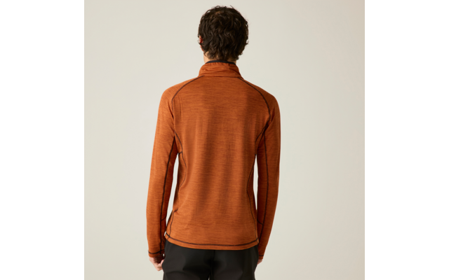 Personne de dos portant un haut orange à manches longues avec coutures visibles, pantalon foncé, fond uni clair