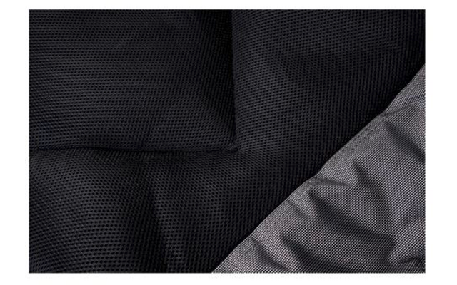 Gros plan sur un tissu noir à texture fine avec une couture visible et un coin gris replié