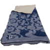 Serviette de plage bleue à motif posée sur du sable clair; herbe de dune, poteaux en bois et ciel bleu en arrière-plan