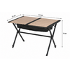 Mesa rectangular con dos paneles de tablero color marrón claro uno junto al otro, estructura metálica negra con patas en X, bolsa de tela negra bajo el centro; flechas de medición que indican 115 cm de ancho, 72 cm de profundidad, 79 cm de altura