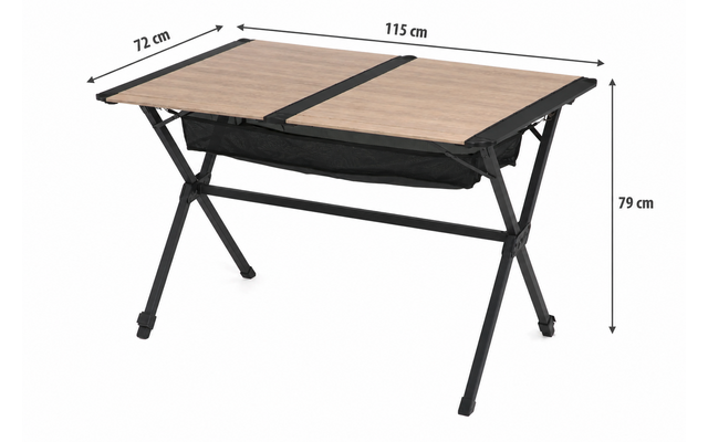 Mesa rectangular con dos paneles de tablero color marrón claro uno junto al otro, estructura metálica negra con patas en X, bolsa de tela negra bajo el centro; flechas de medición que indican 115 cm de ancho, 72 cm de profundidad, 79 cm de altura