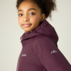 Mädchen mit lockigem, hochgestecktem Haar, trägt eine violette Kapuzenjacke mit Reißverschluss und weißem Berg-Logo auf dem Ärmel, vor hellem einfarbigem Hintergrund