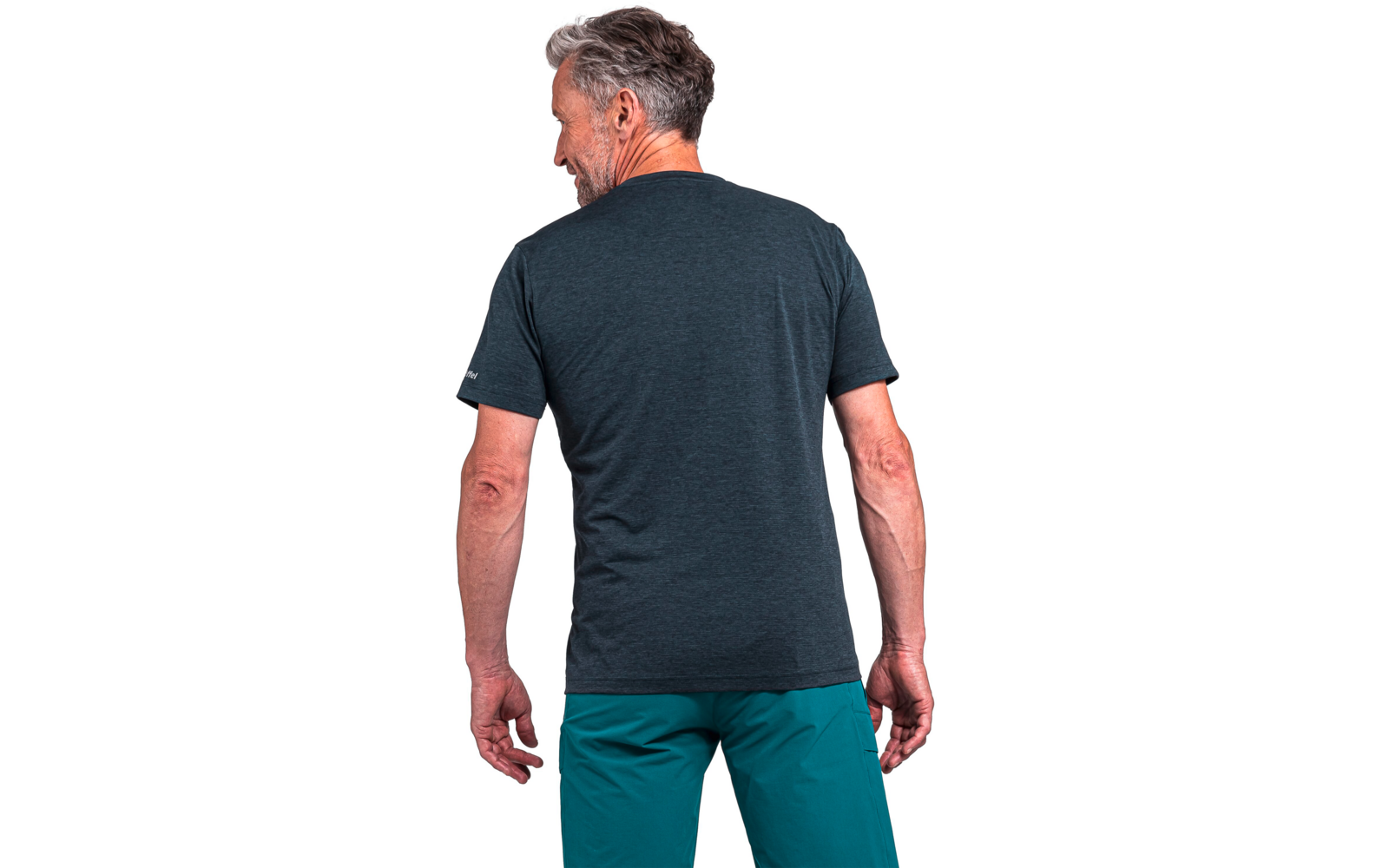 Rückansicht eines Mannes mit grauen Haaren, dunkles kurzärmeliges T-Shirt und türkisgrüne Hosen vor weißem Hintergrund