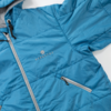 Blauwe gewatteerde jas met capuchon, lichtgrijze ritsen, een ritszak aan de zijkant en een borstlogo