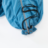Detailopname van een blauwe jaszoom met rits, zwart koord en metalen oogjes op een witte achtergrond
