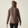 Person von hinten in brauner Jacke und Beanie vor weißem Hintergrund
