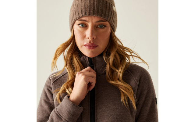 Frau mit beige gestrickter Mütze und braunem Pullover schaut nach vorne