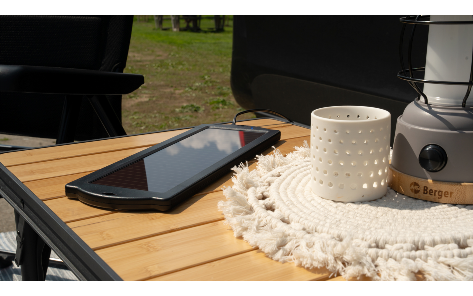 Smartphone und Tasse stehen auf einem Holztisch mit gehäkelter Tischdecke