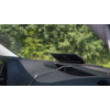 Blick durch die Windschutzscheibe eines Autos auf einen digitalen Tachometer und eine grüne Baumkulisse im Hintergrund