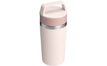 Hellrosa zylindrischer Becher mit pastellrosa Deckel und breitem Griff, silberner Metallring unter dem Deckel