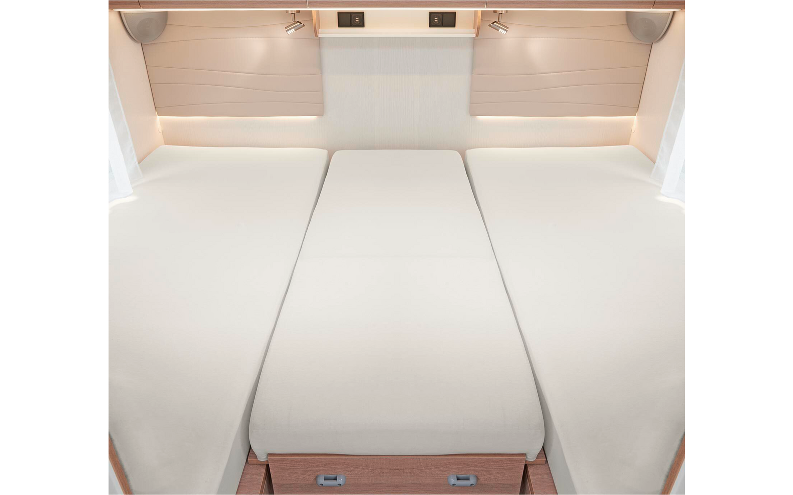 Trois lits simples avec des matelas blancs placés côte à côte dans une pièce lumineuse