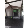 Interieur van een opblaasbare tent met zwarte vloer en lichtgrijze en bruine wanden, zicht door de opening op de geopende schuifdeur en het zijraam van een witte bestelwagen op de achtergrond