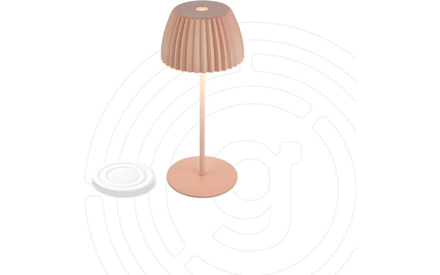 Rosa Tischlampe mit geripptem Lampenschirm, schlankem Stiel und runder Basis; links eine weiße flache runde Scheibe; heller Hintergrund mit dünnen kreisförmigen Linien