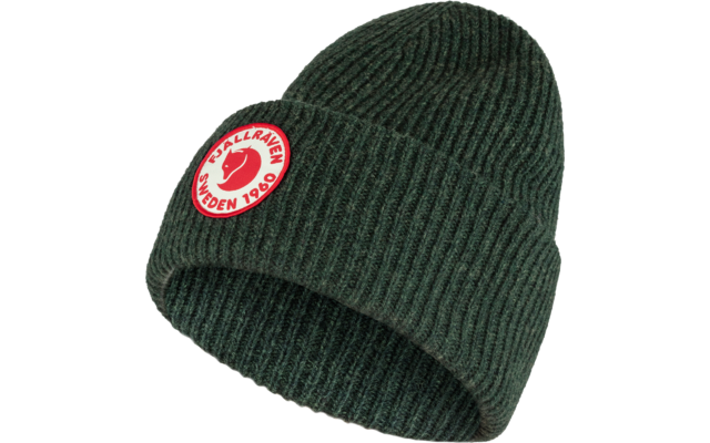Grüne gestrickte Mütze mit einem runden weißen Aufnäher mit rotem Muster