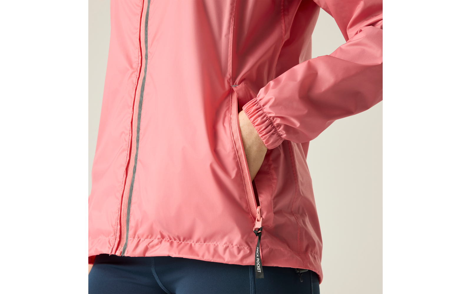 Oberkörper einer Person mit rosa Jacke und Reißverschluss; rechte Hand in Seitentasche; elastisches Ärmelbündchen; sichtbarer Reißverschlussanhänger; unten dunkelblaue Leggings