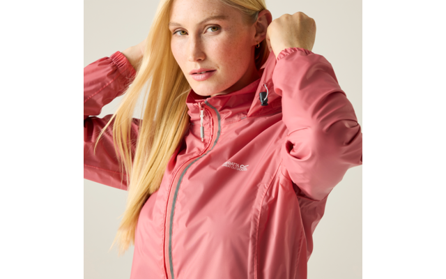 Person mit langen blonden Haaren trägt rosa Regenjacke und hält die Kapuze