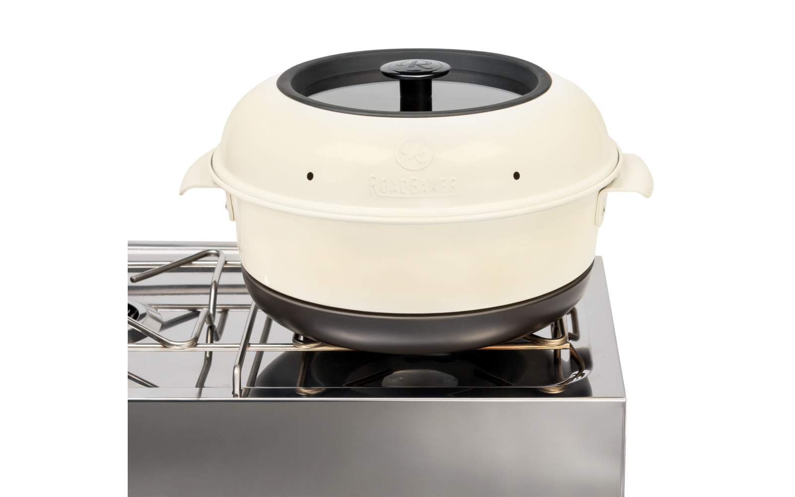 Cremefarbener runder Topf mit schwarzem Deckelknauf auf einem Edelstahl-Gasherd