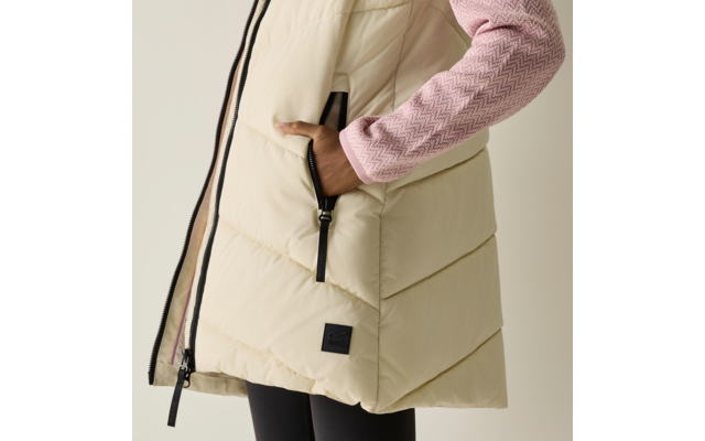 Gilet imbottito color crema con zip nera, mano destra in tasca con zip, manica in maglia rosa con motivo a spina di pesce, parte inferiore mostra leggings neri
