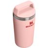 Rosa Becher mit Deckel und integriertem Griff, silberner Metallring und rotes Stanley‑Logo an der Seite