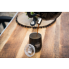 Koffie wordt vanuit een apparaat in een zwarte beker op een houten tafel gegoten