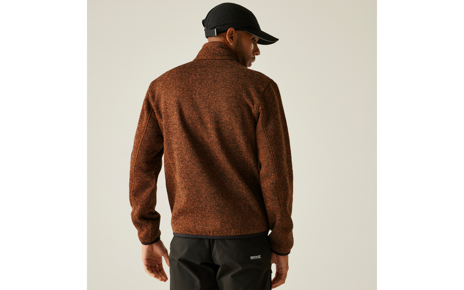 Mann von hinten mit brauner Jacke und schwarzer Mütze