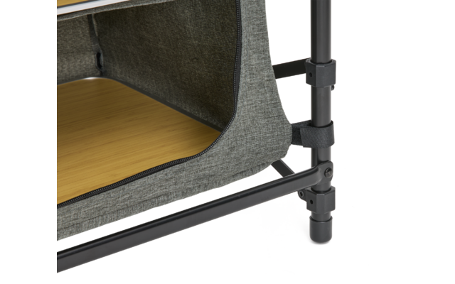 Nahaufnahme einer grauen Stoffhülle mit geöffnetem Reißverschluss, die eine helle Holzfläche zeigt; schwarzer Metallrohrrahmen mit Kunststoffverbindungen und Standfuß sichtbar