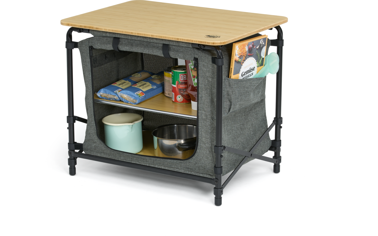 Holztischplatte mit schwarzem Metallgestell und grauer Stoffbox mit offener Vorderseite; oberes Fach mit zwei blauen Packungen und mehreren Dosen/Schachteln; unteres Fach mit hellgrünem Emaillebecher und Edelstahlschüssel; seitliche Tasche mit Prospe