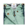 Close-up van de kraag van een mintgroene jas met rits, metalen drukknopen, donkere koorden, paraplupatroon en een stoffen label met een anker