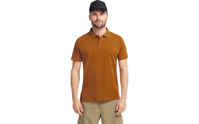 Staande persoon met zwarte baseballpet, bruin poloshirt en beige korte broek