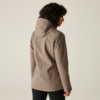 Eine Frau trägt eine beige Jacke und sieht nach hinten