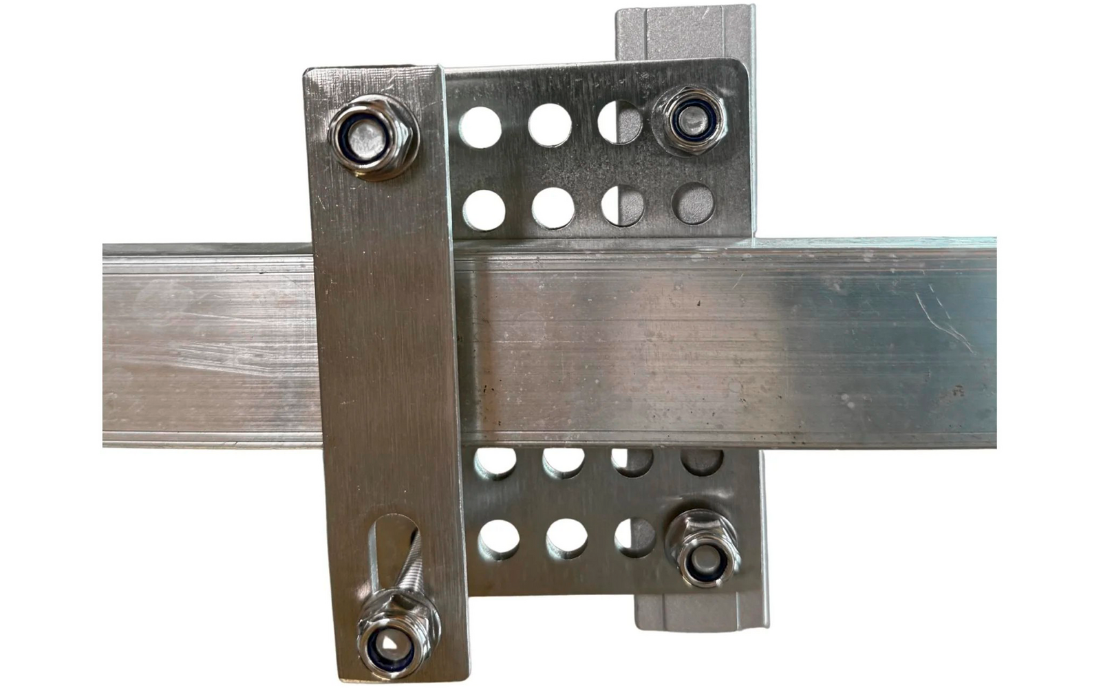 Twee elkaar kruisende aluminiumprofielen met twee geperforeerde metalen platen, een rechte metalen strip met langgat en vier bouten met moeren en ringen op witte achtergrond