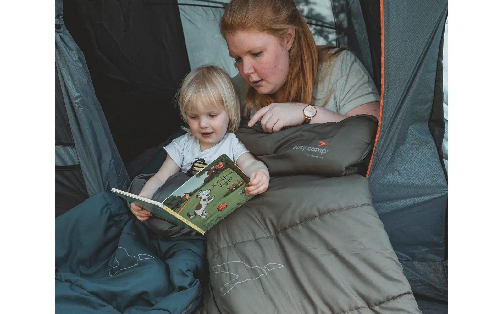 Frau und Kind sitzen zusammen und schauen in ein Buch
