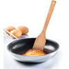 Stainless-steel frying pan with black nonstick interior holding a round golden-brown potato piece lifted by a wooden spatula; three raw potatoes in the background on a white surface