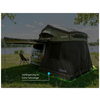 Van with roof-top tent and attached dark fabric annex, folding chair on the shore of a lake, trees and sky in the background