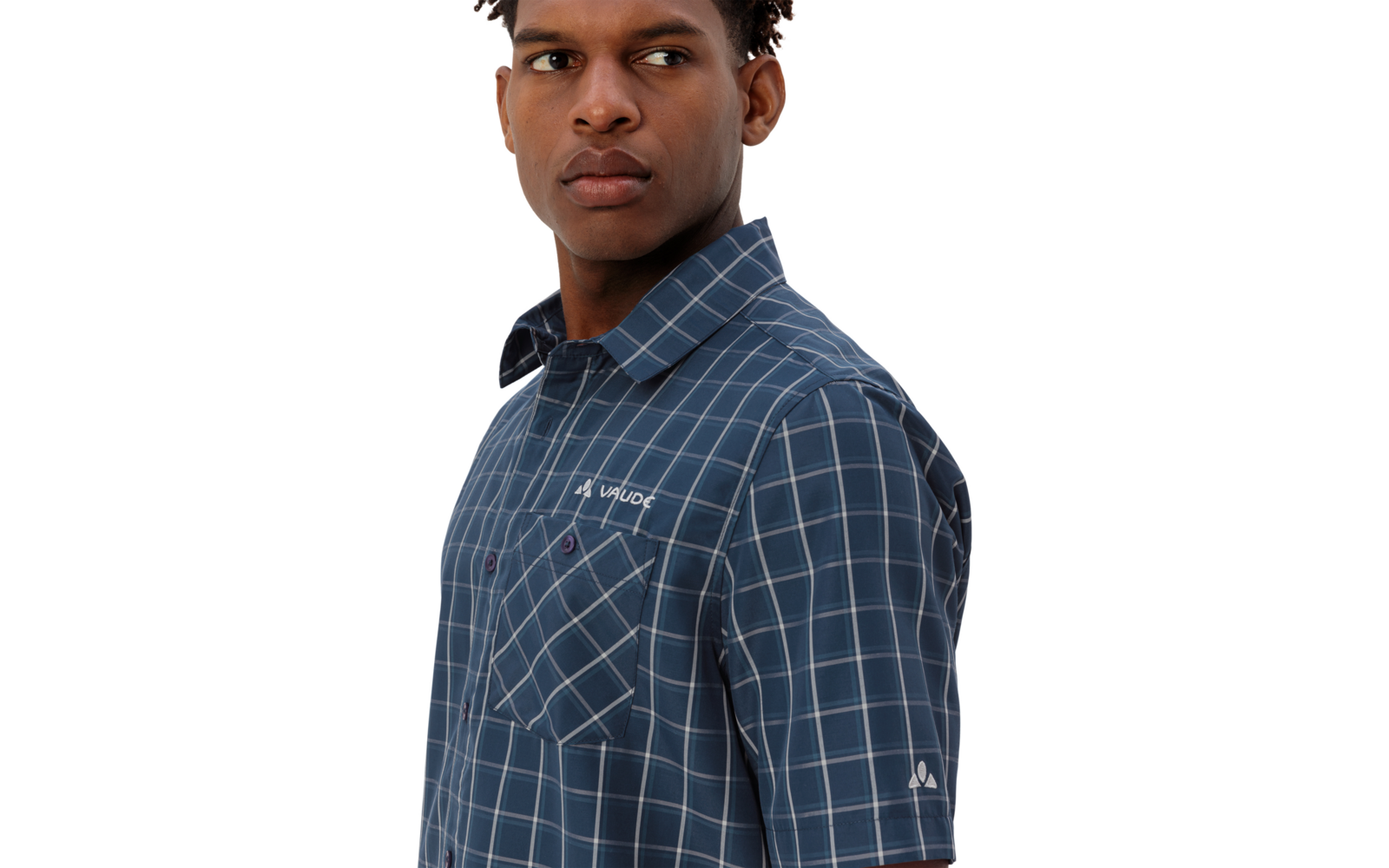 Person mit kurzem dunklem Haar, trägt blau kariertes Kurzarmhemd mit Brusttaschen und weißer Stickerei, Blick nach links, weißer Hintergrund