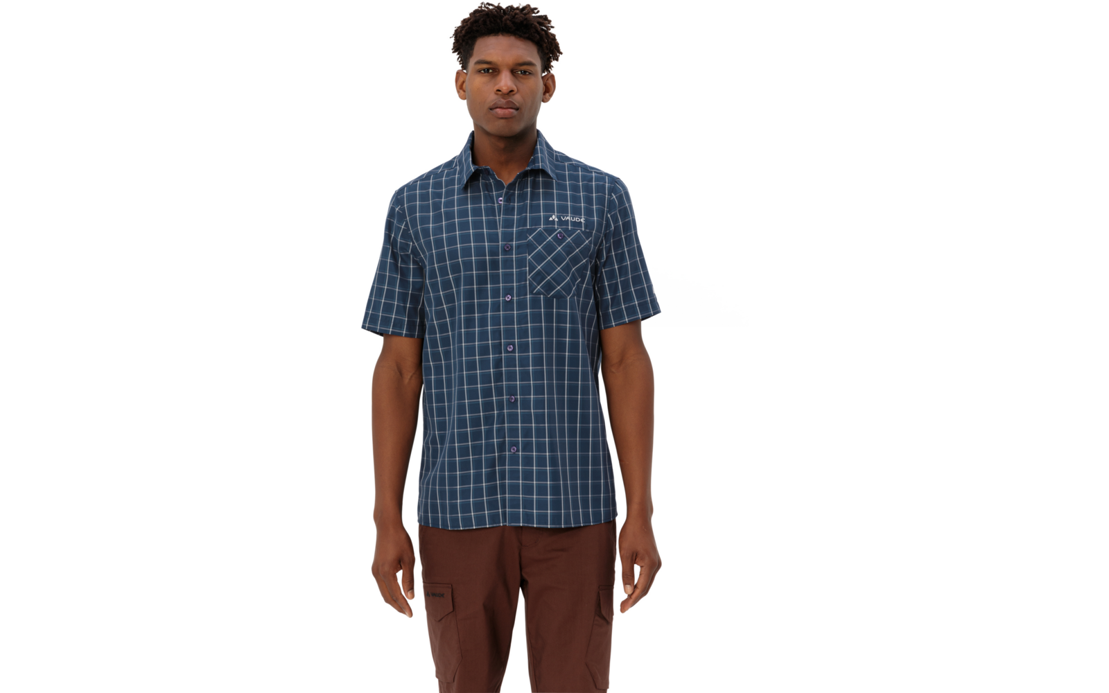 Mann steht frontal, trägt blau-kariertes kurzärmeliges Hemd mit Brusttasche und braune Hose, weißer Hintergrund