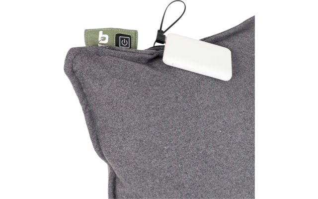 Grijs kussen met stofstructuur, groen label met witte 'b' en een stroompictogram, en een wit rechthoekig apparaat aan een zwart koord
