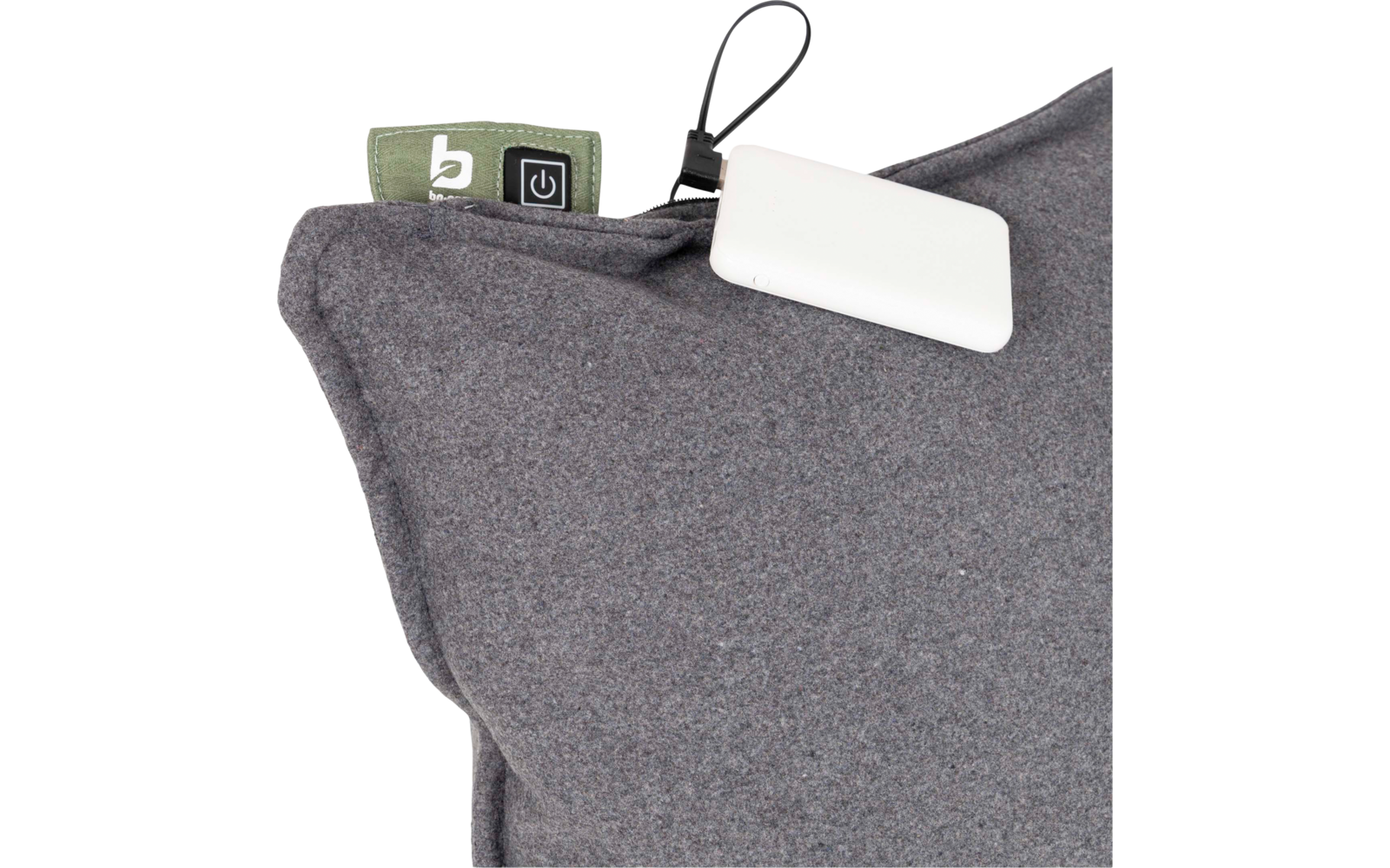 Grijs kussen met stofstructuur, groen label met witte 'b' en een stroompictogram, en een wit rechthoekig apparaat aan een zwart koord