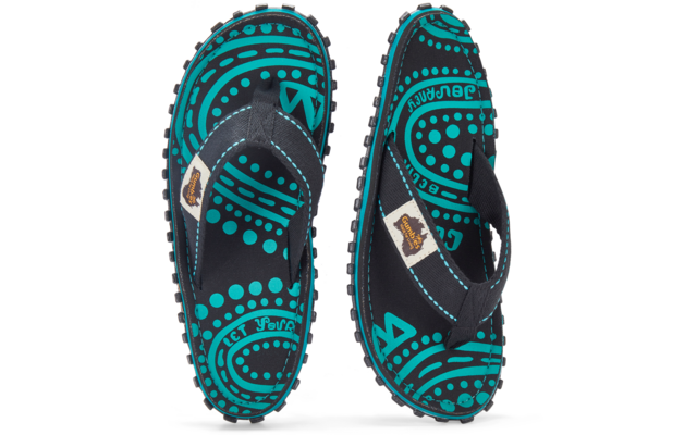 Two black flip‑flop sandals viewed from above, turquoise circular and dotted pattern, black fabric straps, studded soles, white labels with brown logo on the straps