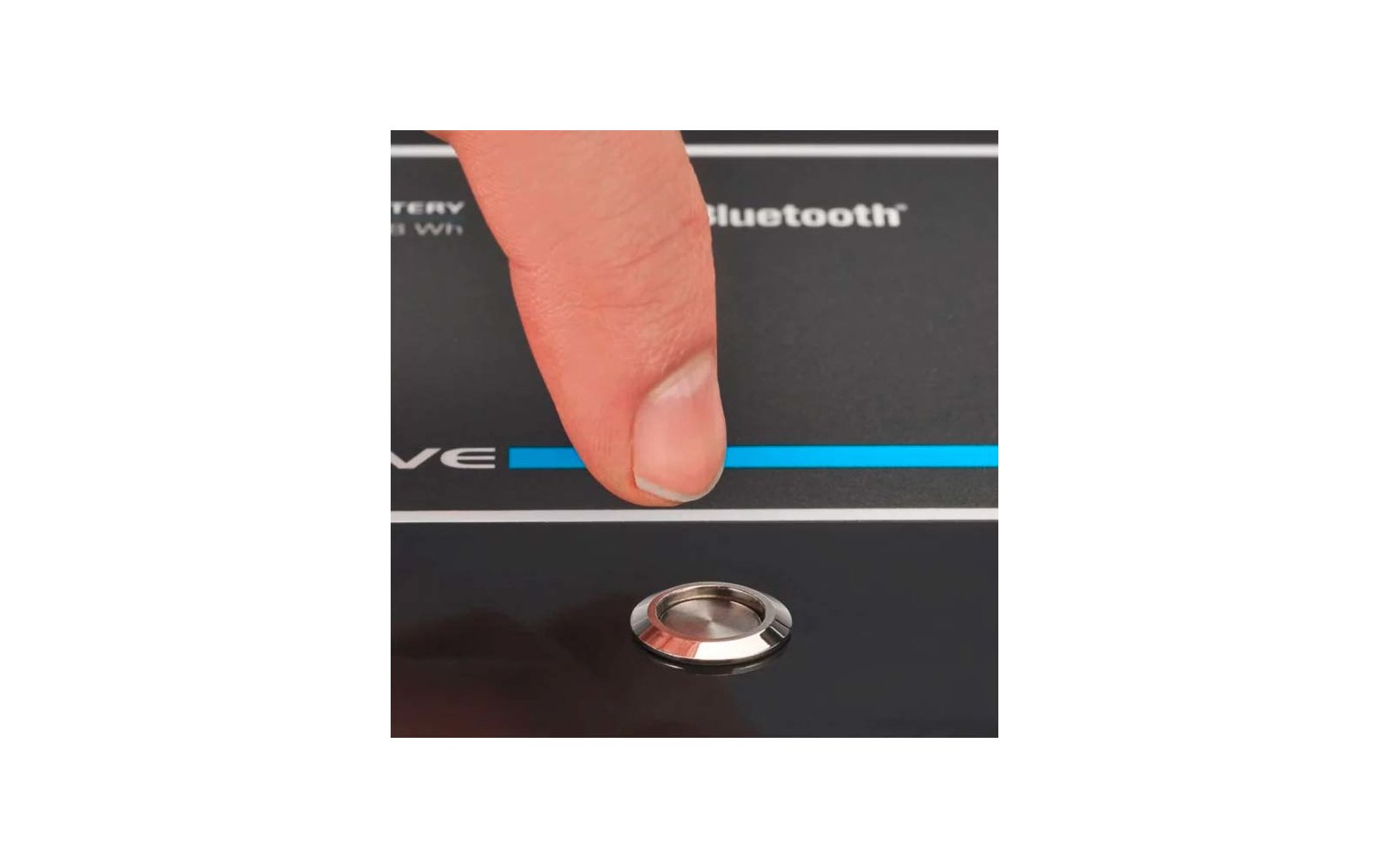 Finger zeigt auf einen blauen Streifen und eine runde Taste auf einem schwarzen Gerät