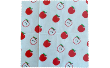 Tissu avec un motif de tomates rouges entières et coupées en deux sur un fond clair