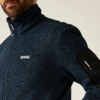 Mann trägt einen dunkelblauen Pullover mit Reißverschluss und Ärmelreißverschluss