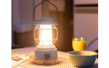 Eine leuchtende Laterne auf einem Tisch mit einer Tasse, einem Glas Orangensaft und einer Schüssel