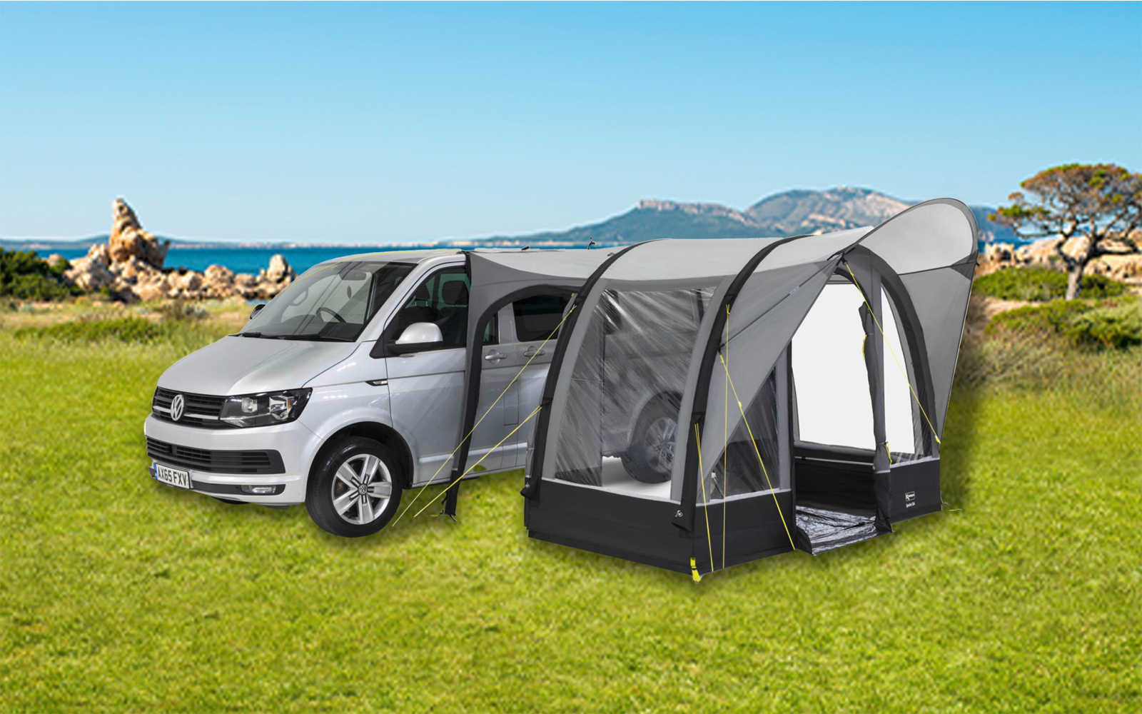 Coche gris con toldo gris sobre césped verde frente a rocas y cielo azul