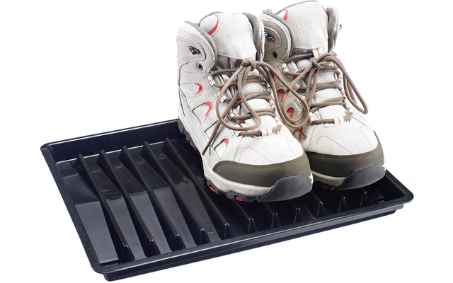 Deux bottines gris clair montant à la cheville avec lacets et accents rouges sur un plateau à chaussures en plastique noir à rainures