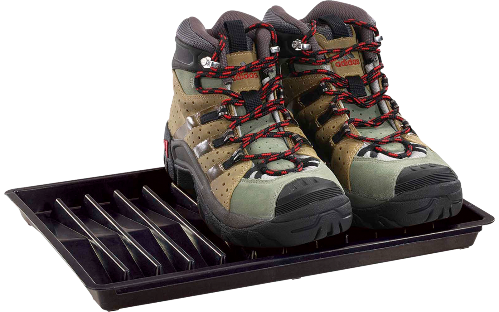 Une paire de chaussures de randonnée brun-vert avec lacets rouges sur un bac à chaussures en plastique noir sur fond blanc