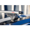 Silberne Metall-Quertraverse mit MontBlanc-Logo und schwarzem Befestigungsfuß auf dem Dach eines blauen Autos