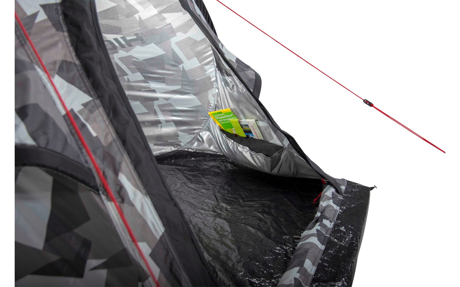 Interieur van een tent met grijs geometrisch patroon, open ingang, rood spankoord buiten, zwarte vloer, binnenzak met geelgroen plastic voorwerp