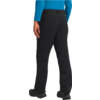 Beine und Unterkörper einer Person in schwarzer Hose und blauer Jacke